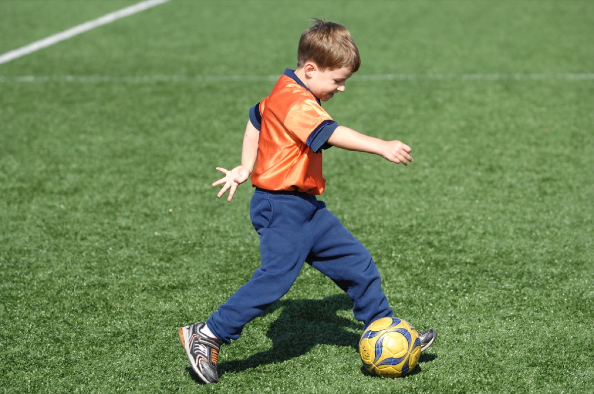 Un ballon de football professionnel sur la pelouse d'un grand stade.
