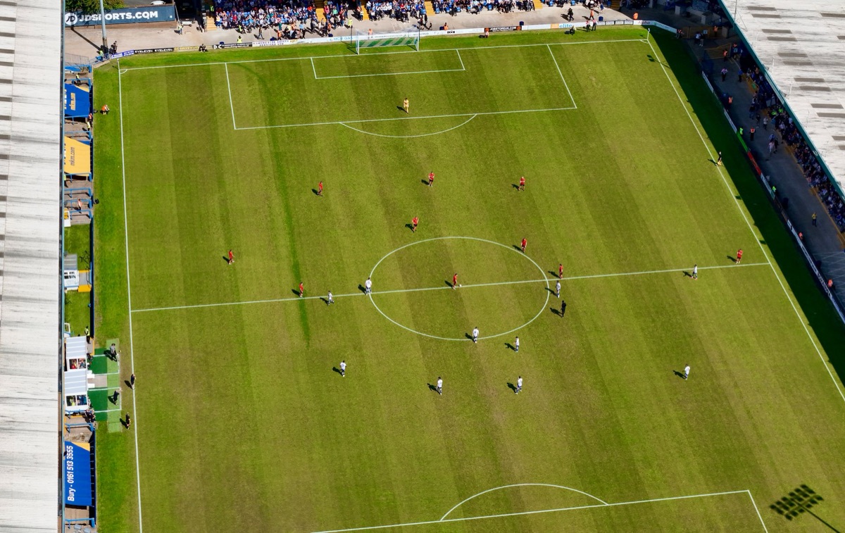 Empty sidelines of a large football pitch during golden hour
