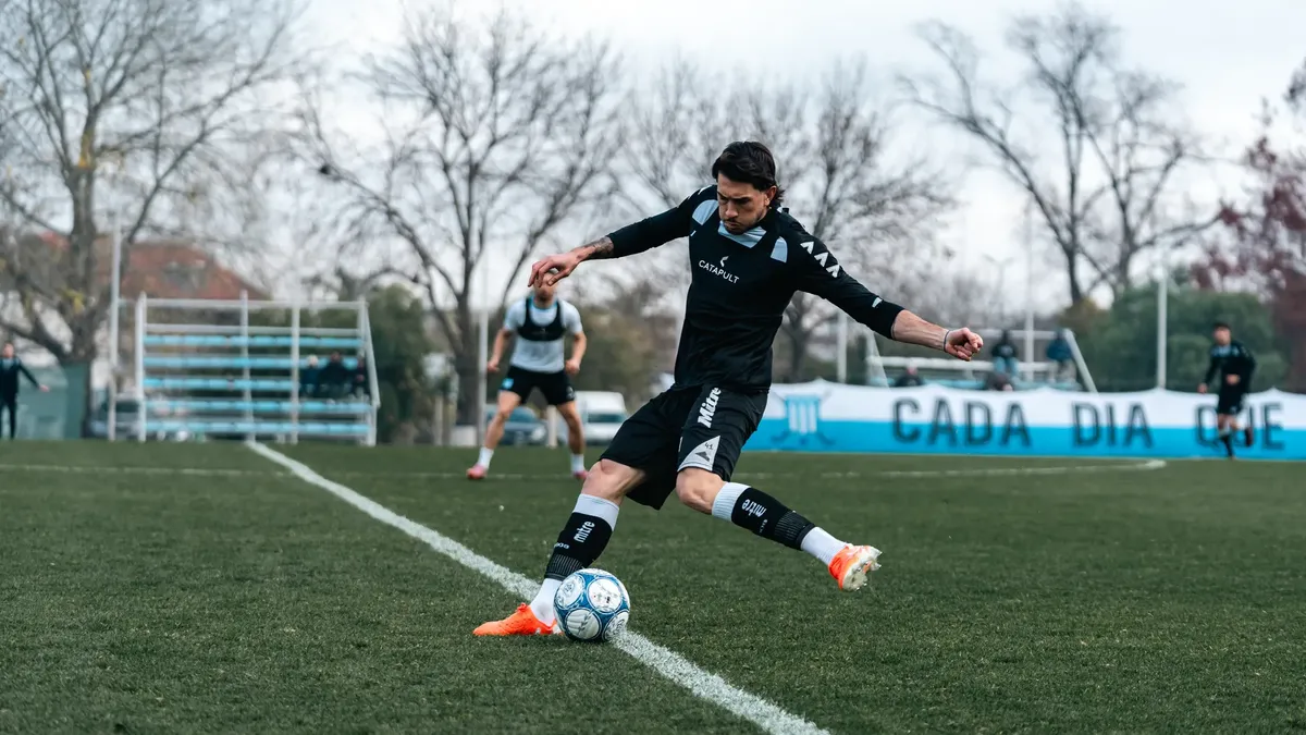 Focused soccer player executes a powerful kick on a grass field during training.