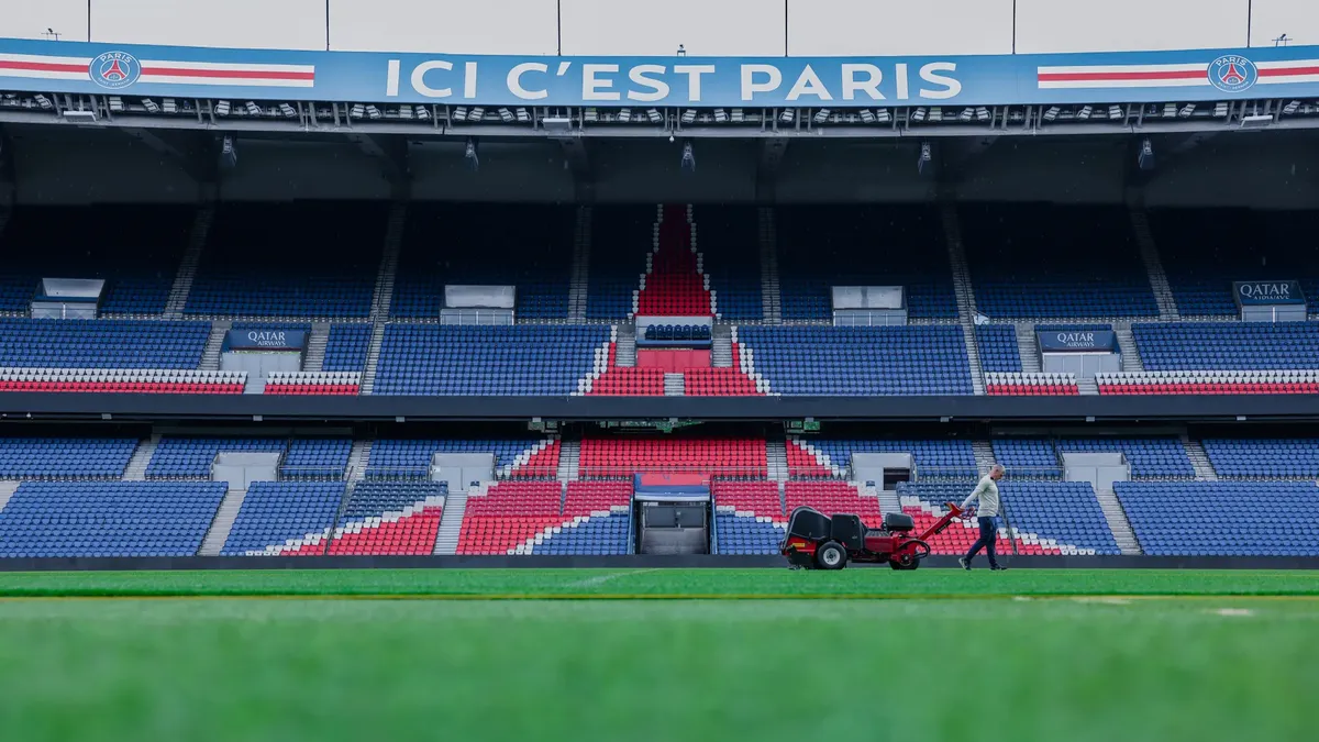 Gardener working on the field at Parc des Princes stadium, Paris. Vibrant and iconic sports venue.