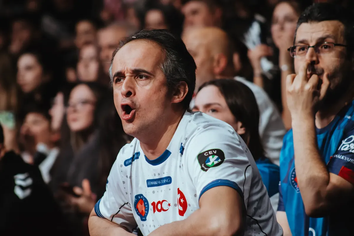 Passionate fans in a crowd showing excitement at a sports event. Engaging atmosphere and team spirit.